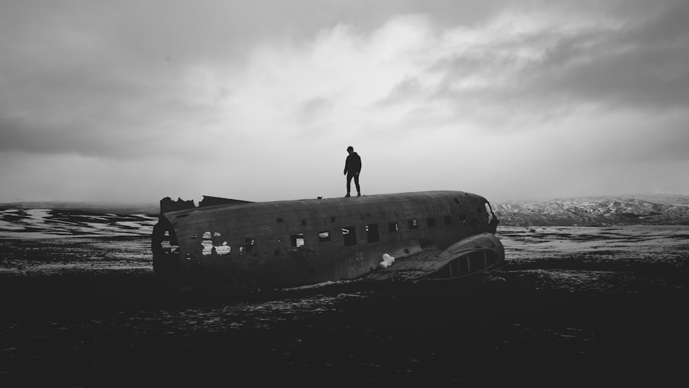 silhouette of man on top of wrecked airplane