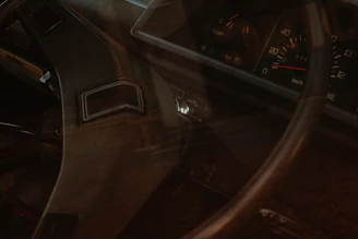 A close-up of a vintage car dashboard with worn leather and classic dials, evoking the spirit of rat road culture.
