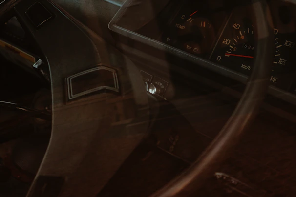 A close-up of a vintage car dashboard with worn leather and classic dials, evoking the spirit of rat road culture.