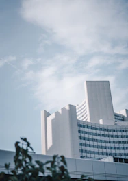 A sleek office building with green plants and solar panels under a clear blue sky.