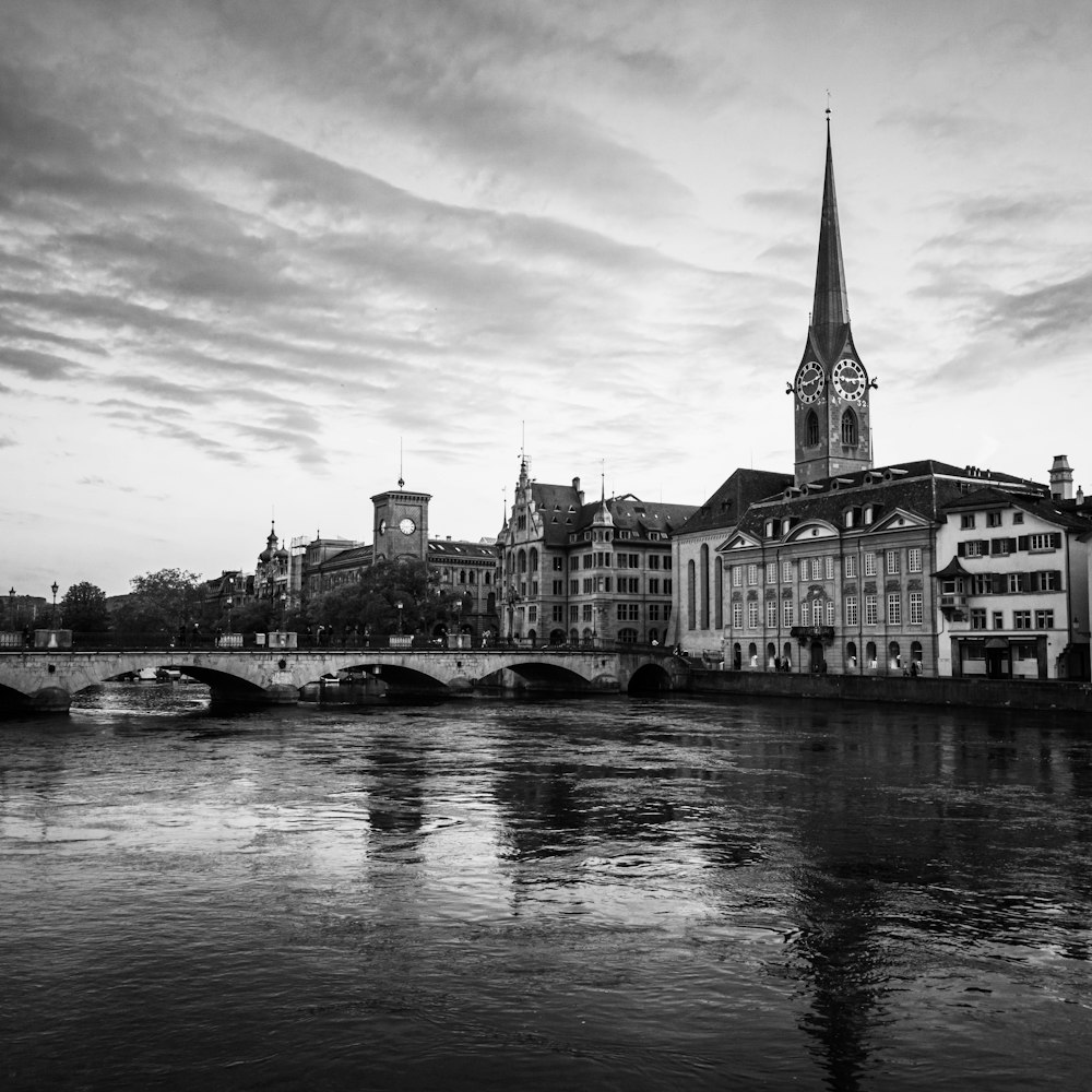 grayscale photo of buildings near body of water