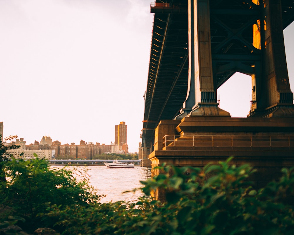 a bridge over a body of water with a city in the background