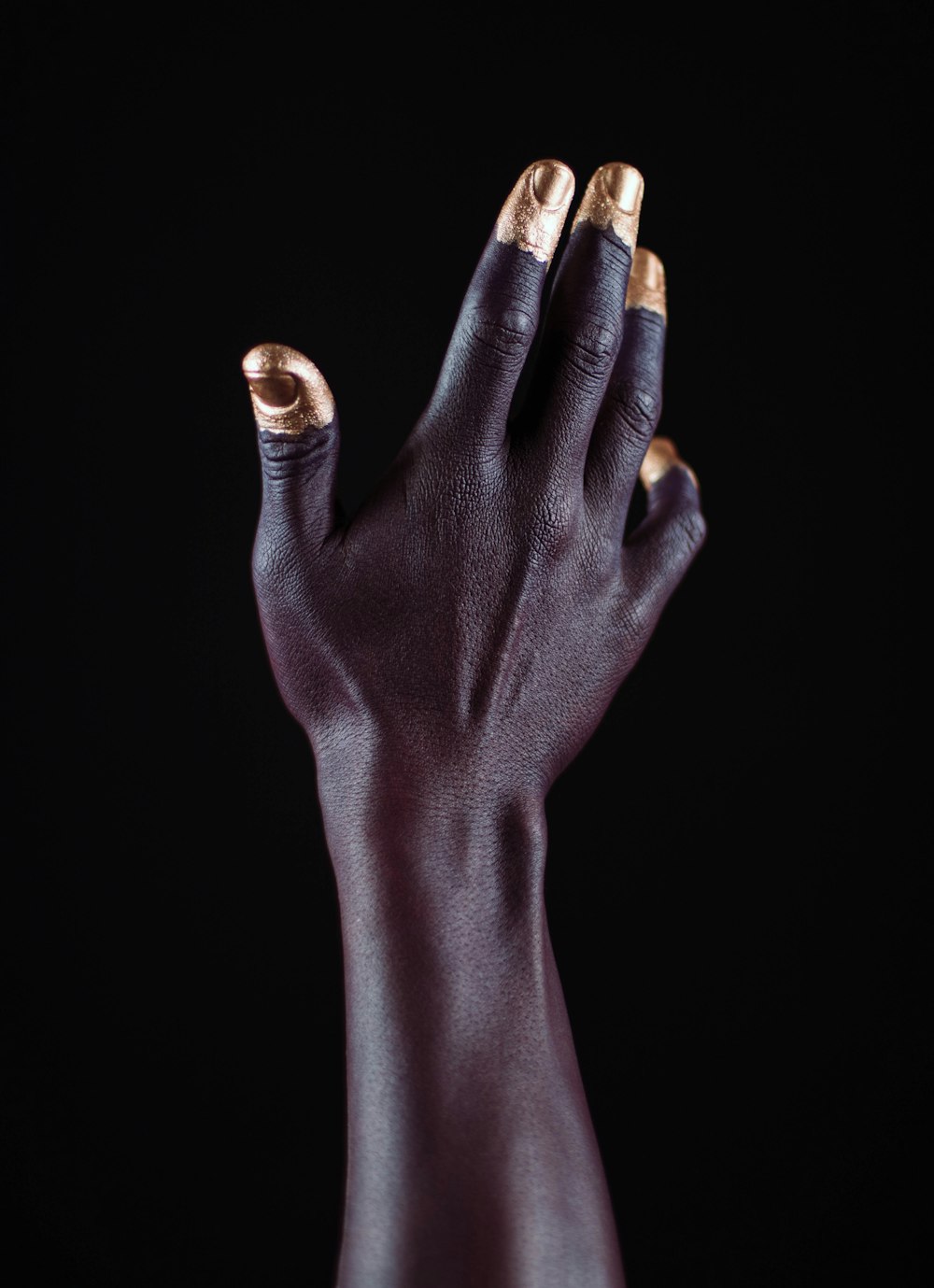 gold-dipped person's fingers