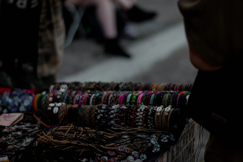 Handcrafted colorful beaded bracelets displayed on a rustic wooden table.