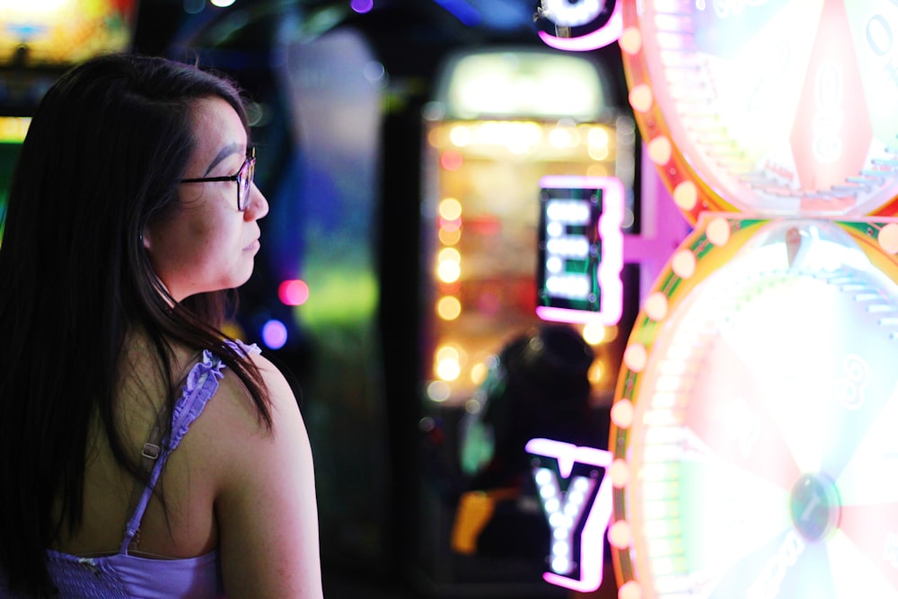 selective focus photography of woman standing beside lights