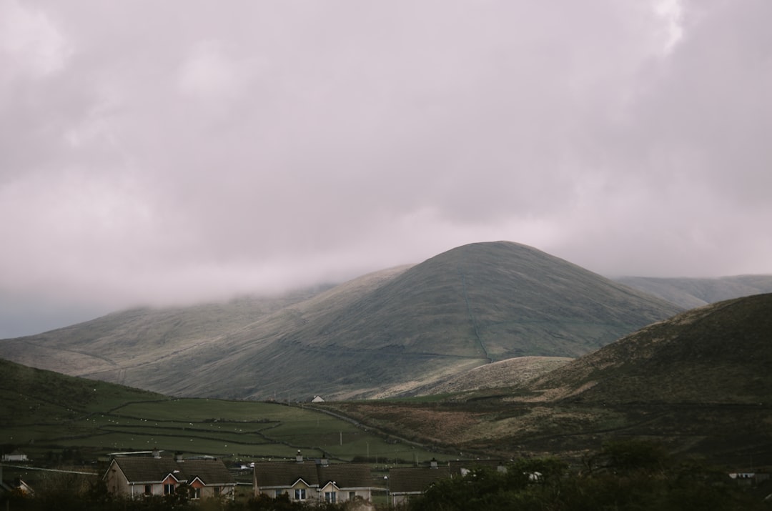 aerial photography of green mountain under cloudy sky