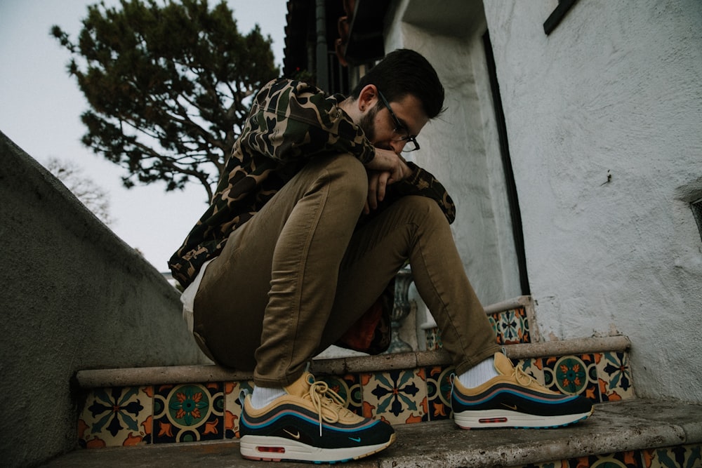 man sitting on stairs during daytime