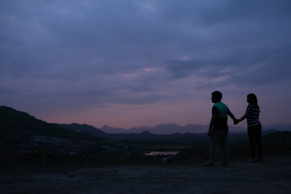 silhouette of man and woman standing and holding hands