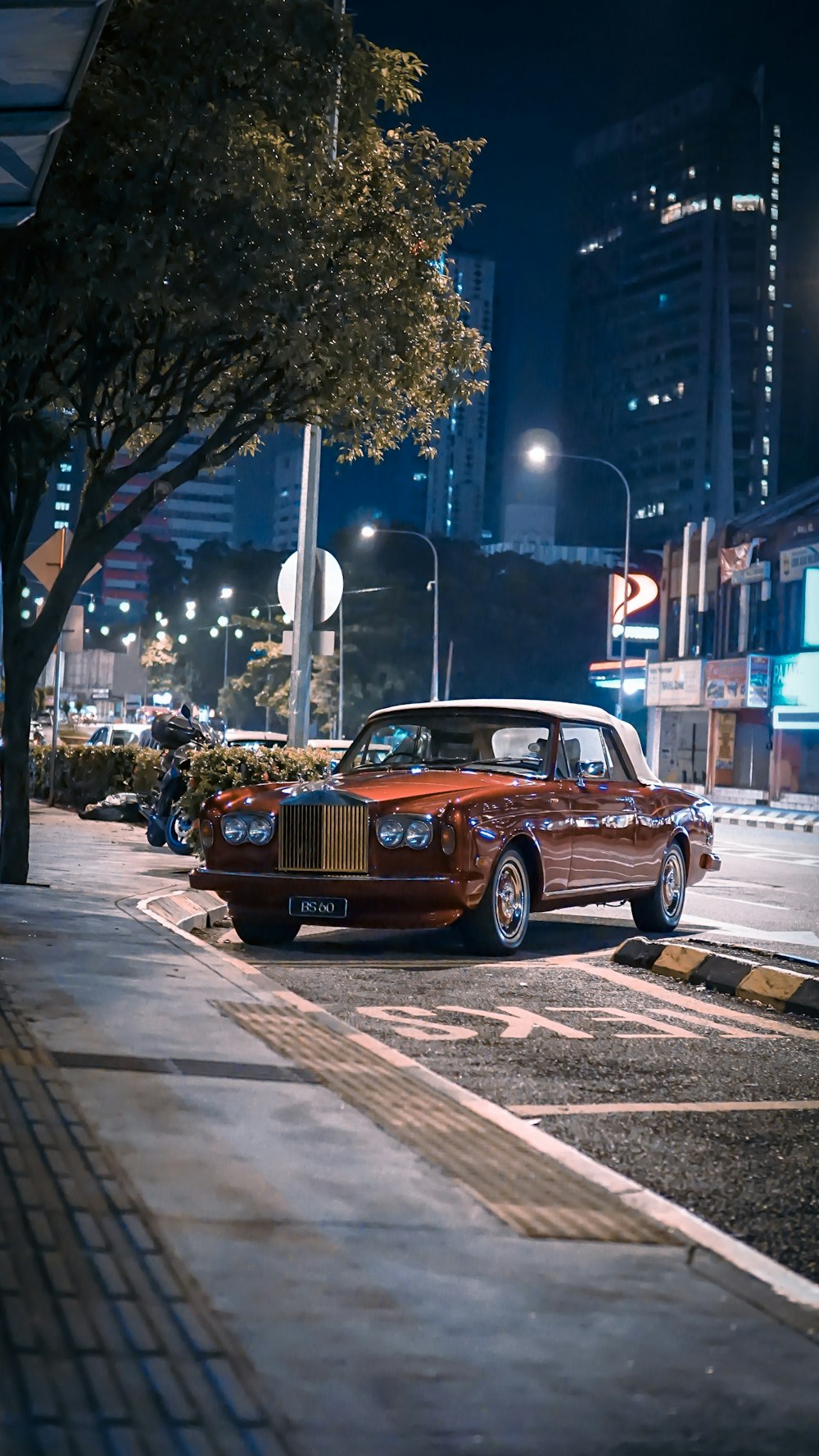 classic orange coupe parked beside curb