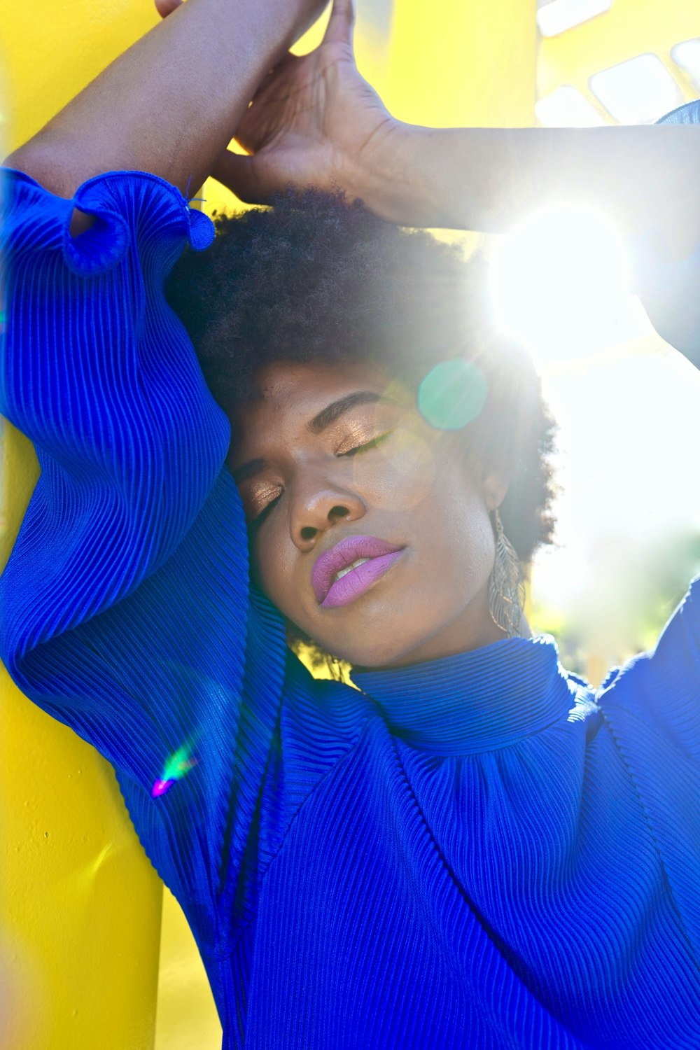 woman leans on yellow all