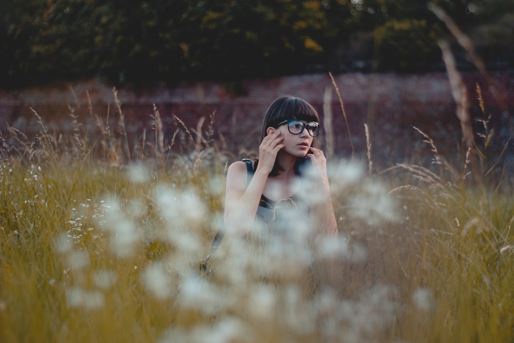 woman sitting on brown grass