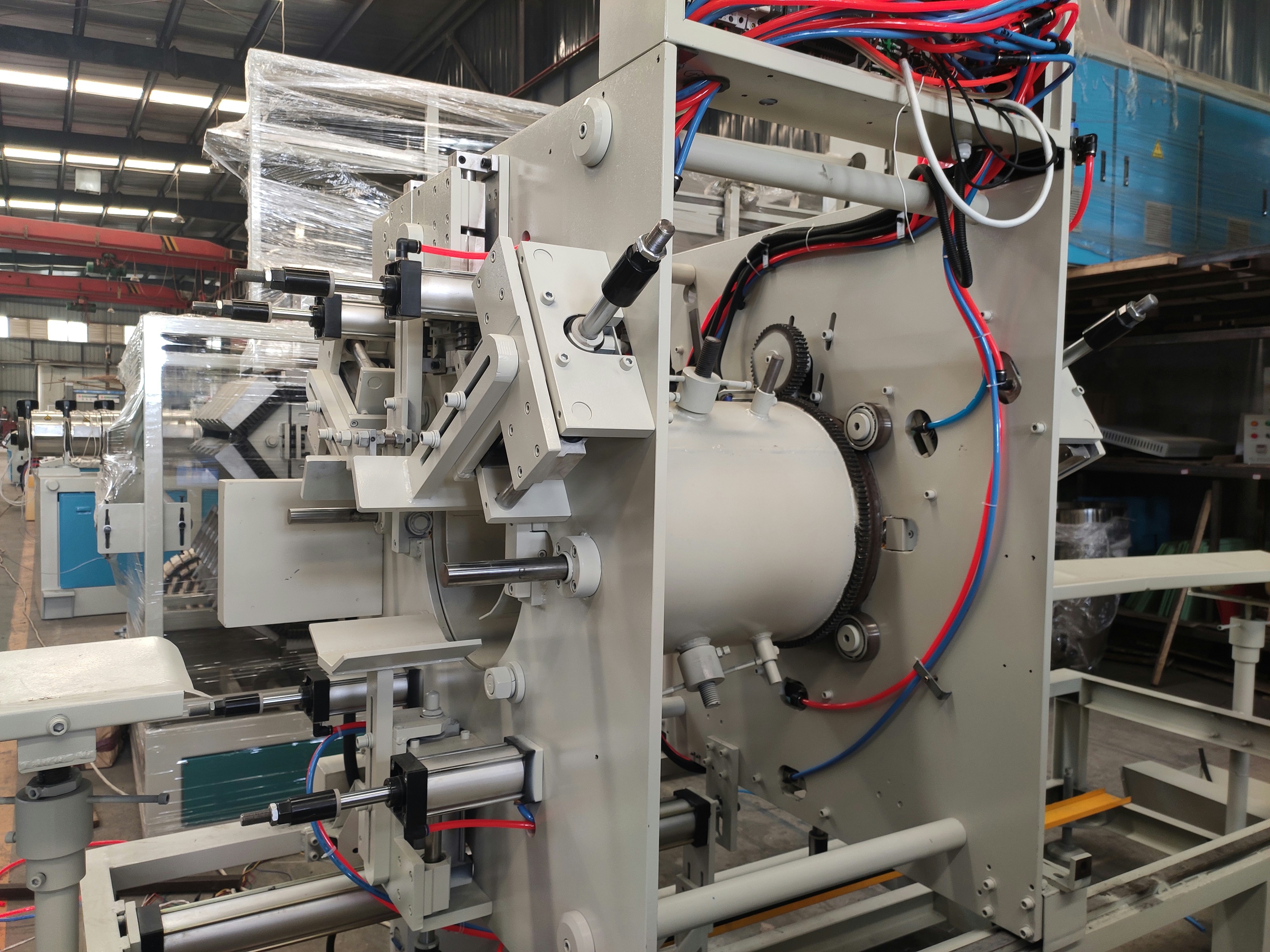 Heavy industrial machinery with large metal gears and rotating equipment in a factory floor
