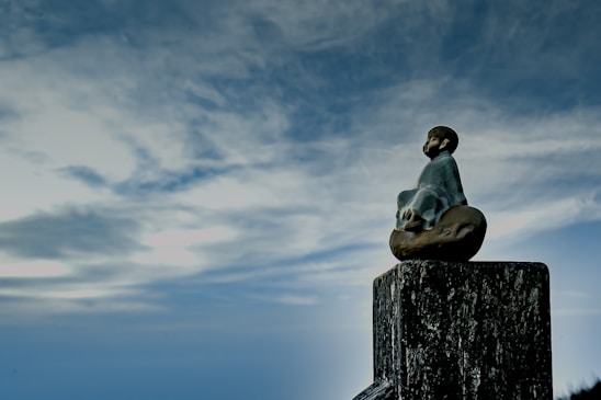 A serene figure meditating under a violet and indigo sky, surrounded by soft golden light.