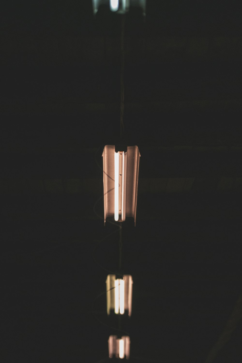 a light hanging from a ceiling in a dark room