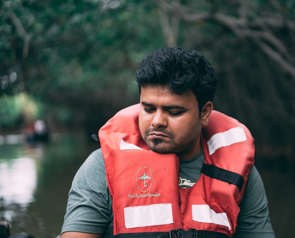 shallow focus photo of man wearing red lifevest