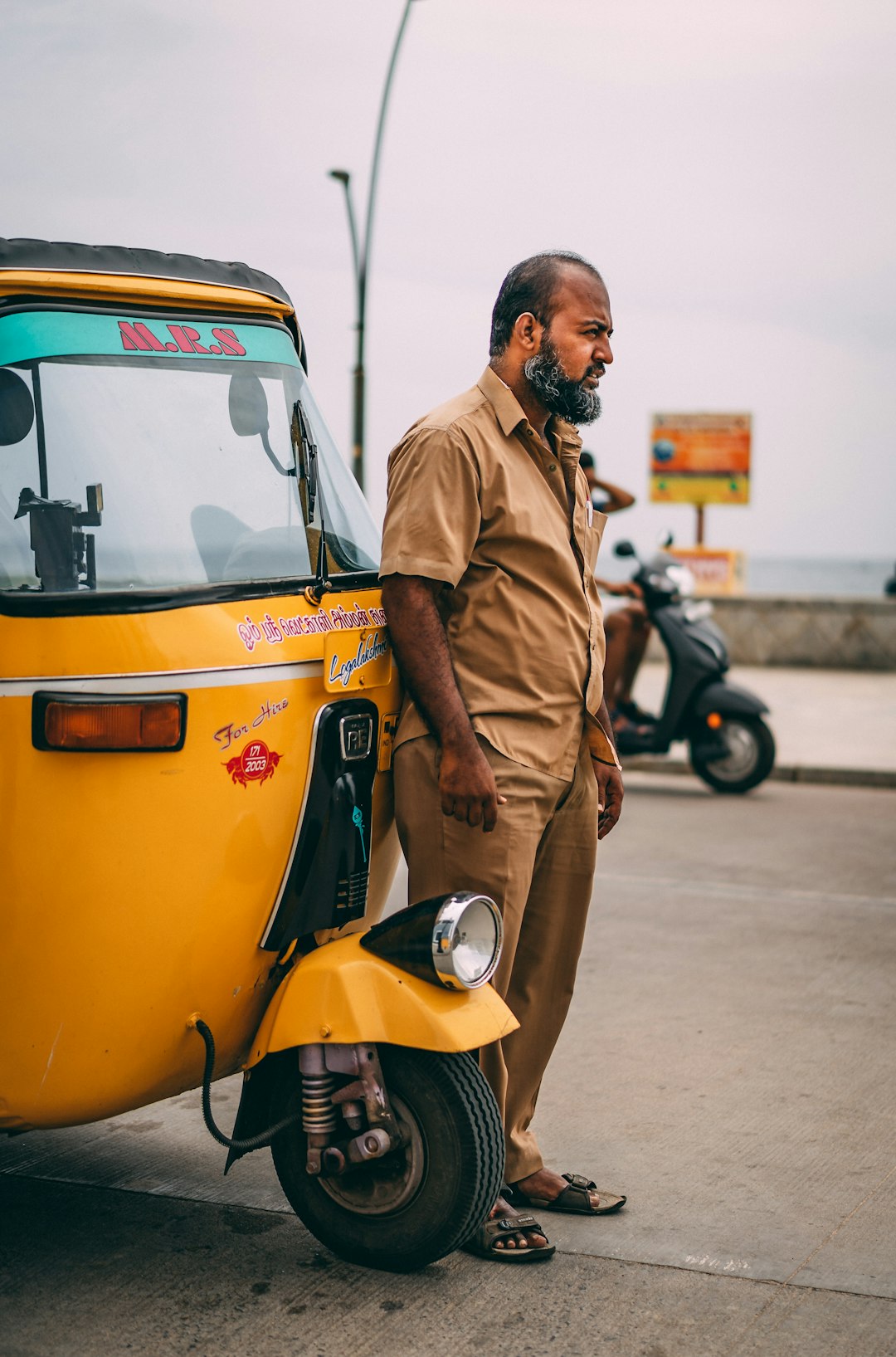 man stand in front yellow autorickshaw