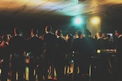 A joyful choir performing in a rustic hall filled with natural light.