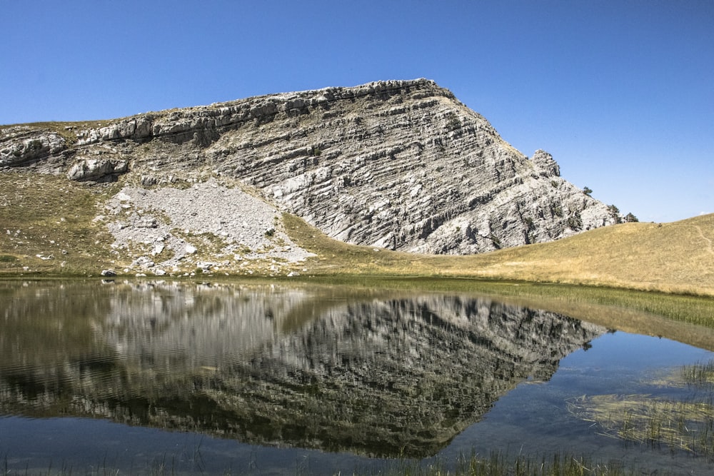 grey cliff near body of water