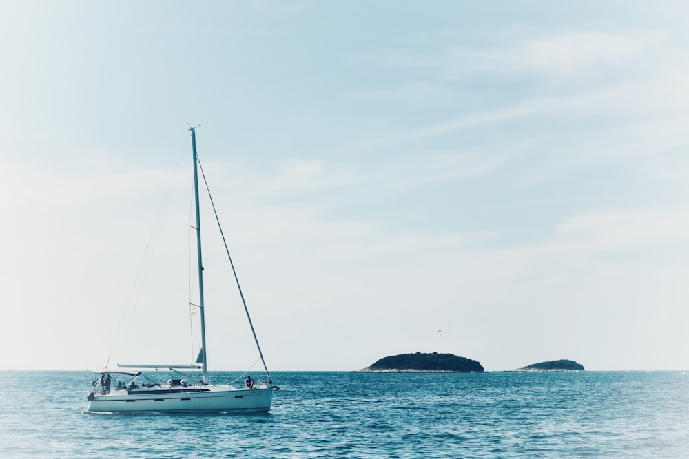 sailboat at the sea with islet background