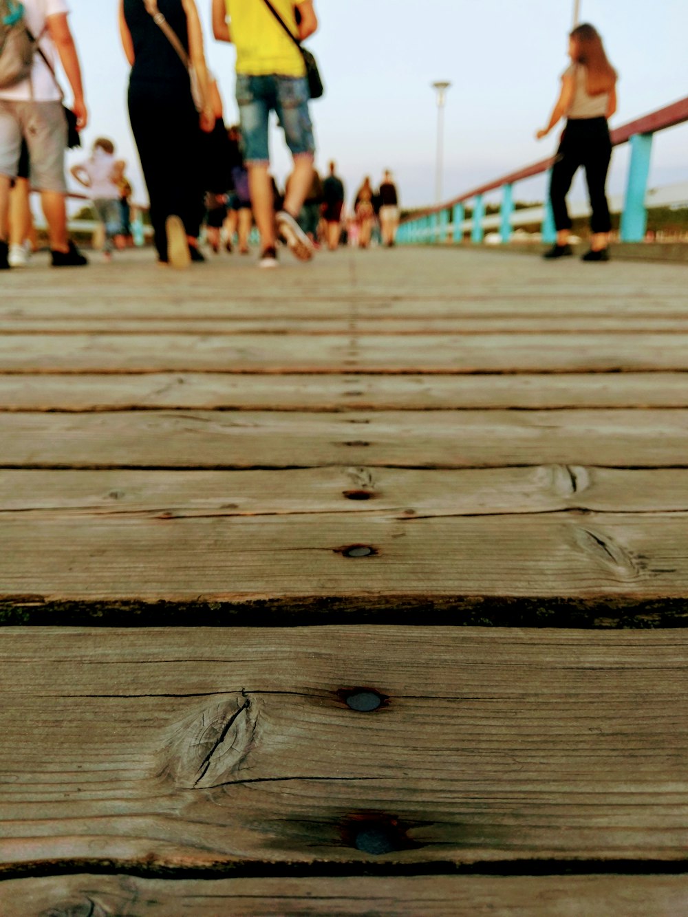 a group of people walking across a wooden bridge