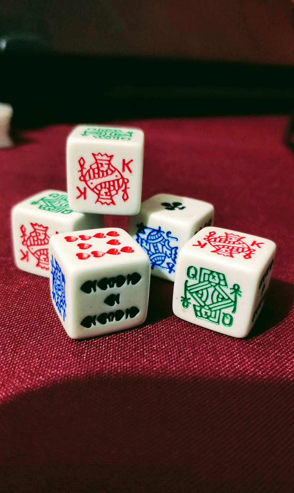 five playing dies on red cloth
