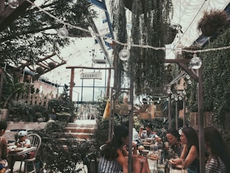a group of people sitting at a table in a garden
