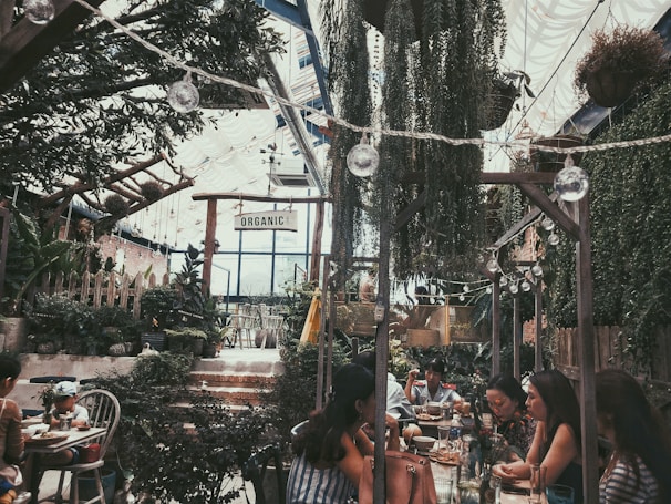 a group of people sitting at a table in a garden