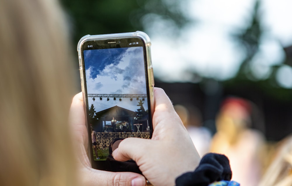 person holding phone while taking picture