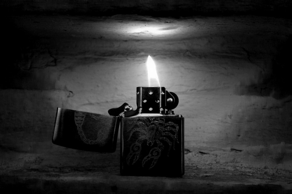 grayscale photography of turned-on flip lighter