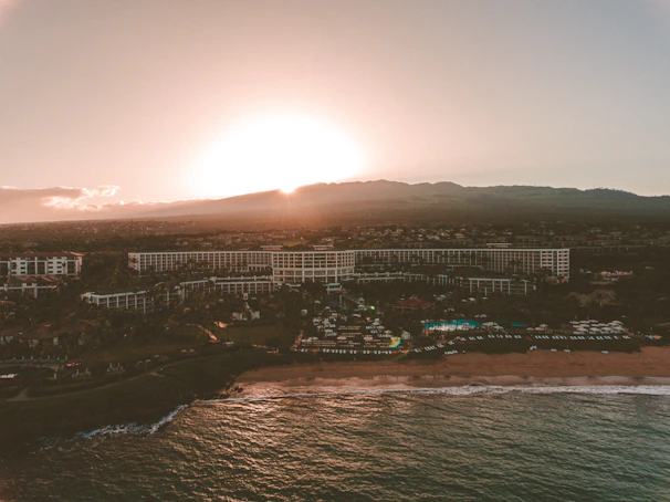 A sweeping aerial shot of a luxury Norfolk coastal holiday let bathed in golden sunset light.