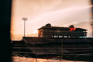 Wide view of newly renovated club stadium bathed in warm orange lights at sunset