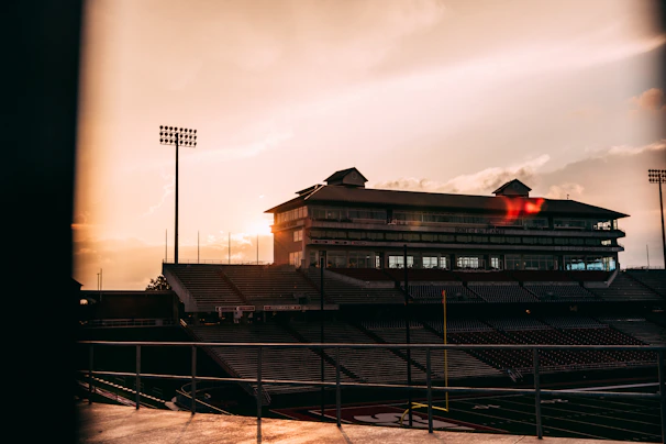 Outside shot of a famous stadium’s grand entrance bathed in golden sunset light.