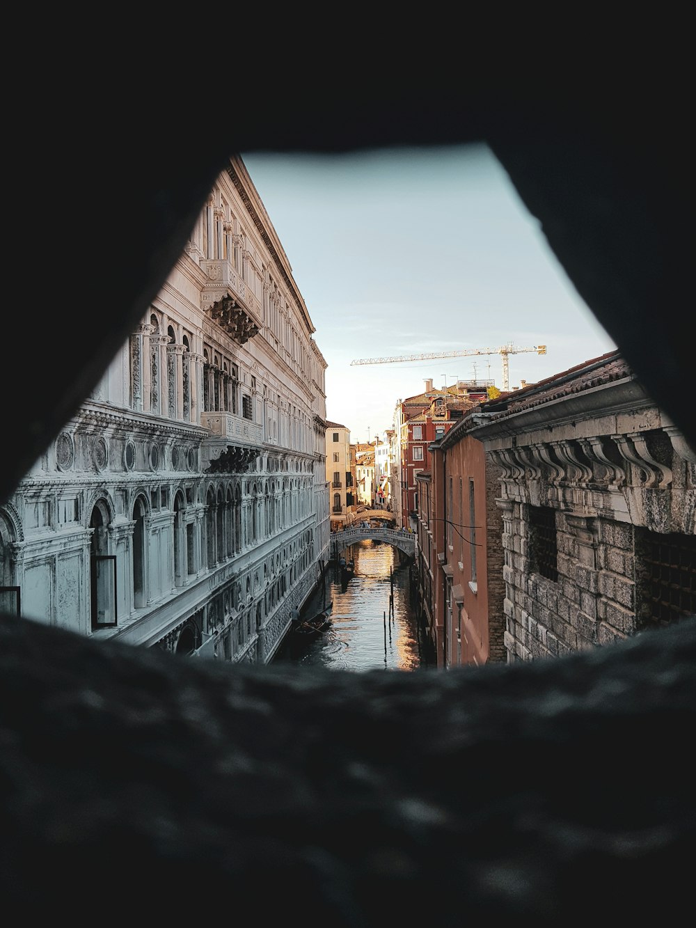 a view of a canal through a hole in a wall