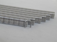 An employee carefully inspecting a batch of staplers on the production line.