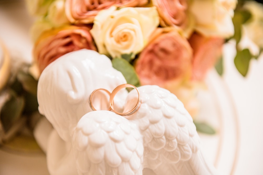 two gold-colored rings on cherub figurine