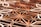 Intricate geometric wooden patterns with a three-dimensional effect, composed of various polygons and shapes. The use of warm colors with subtle variations gives it an artistic and architectural quality.
