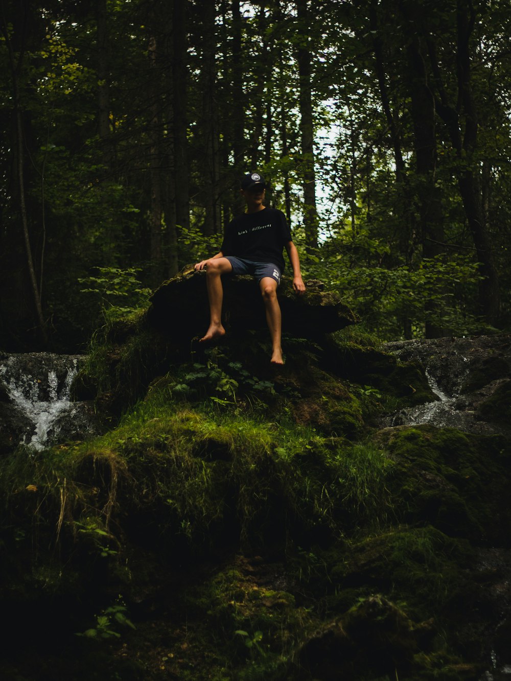 close-up photography of man sitting stone