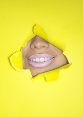 ripped yellow paper showing woman's nose and lips