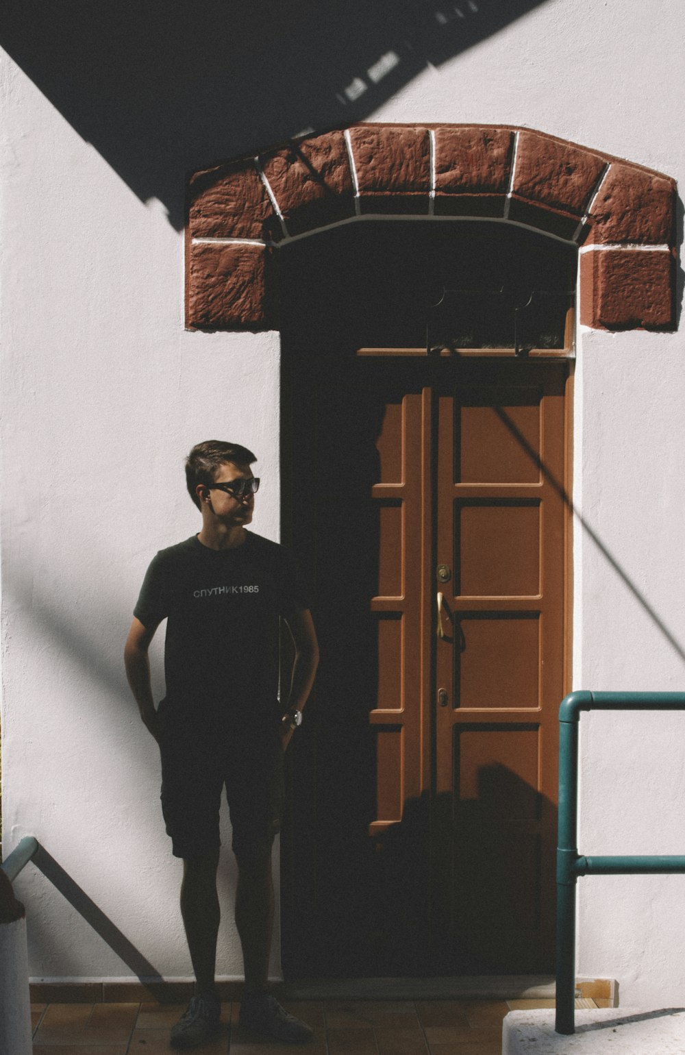 man standing in front of brown wooden door