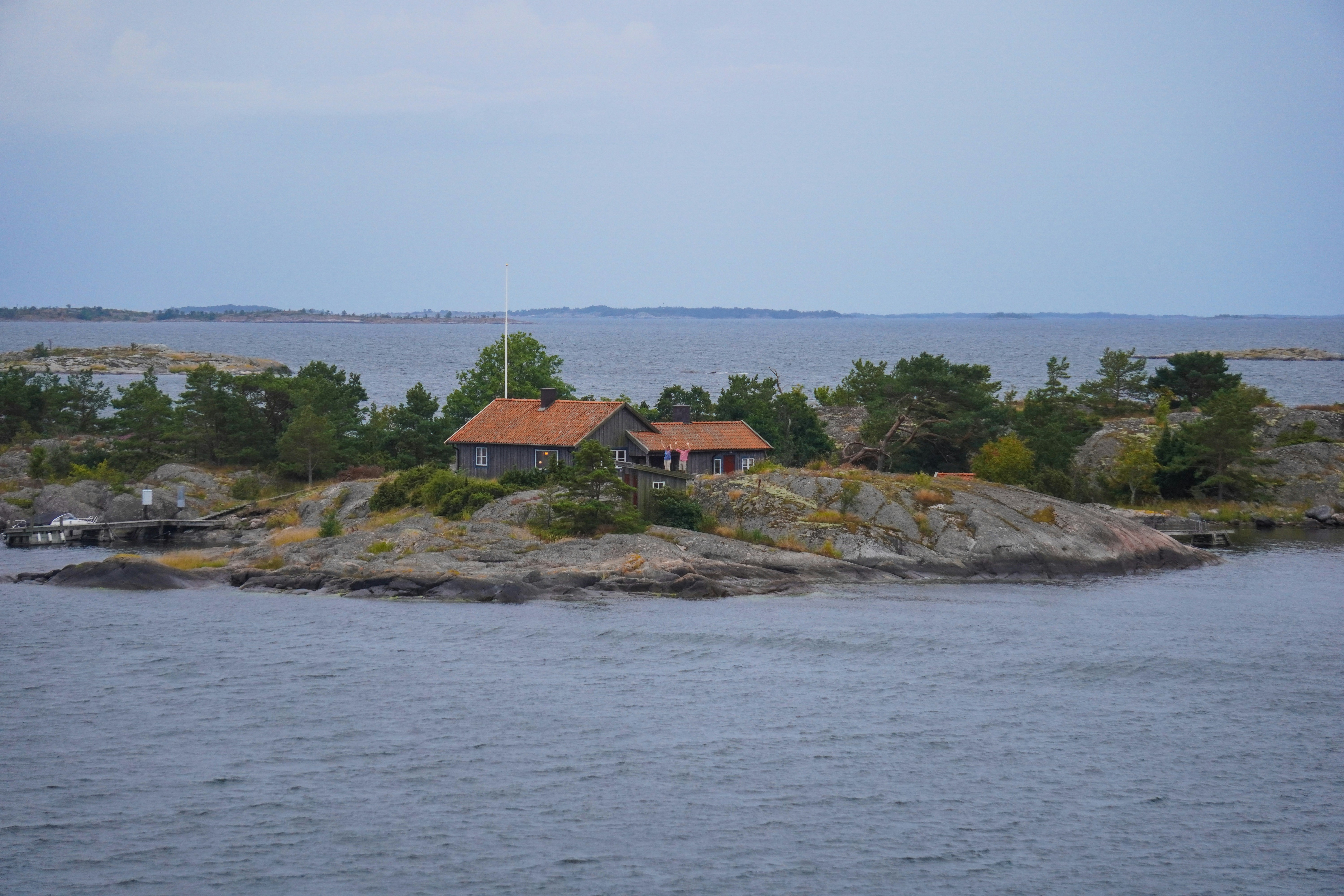 brown and gray house near ocean under blue sky