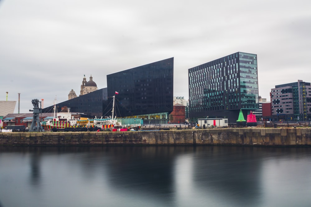 buildings near body of water under cloudy