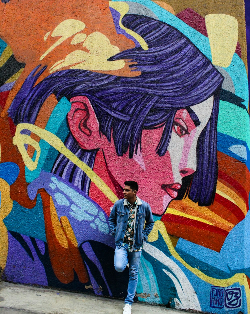 man leaning on mural