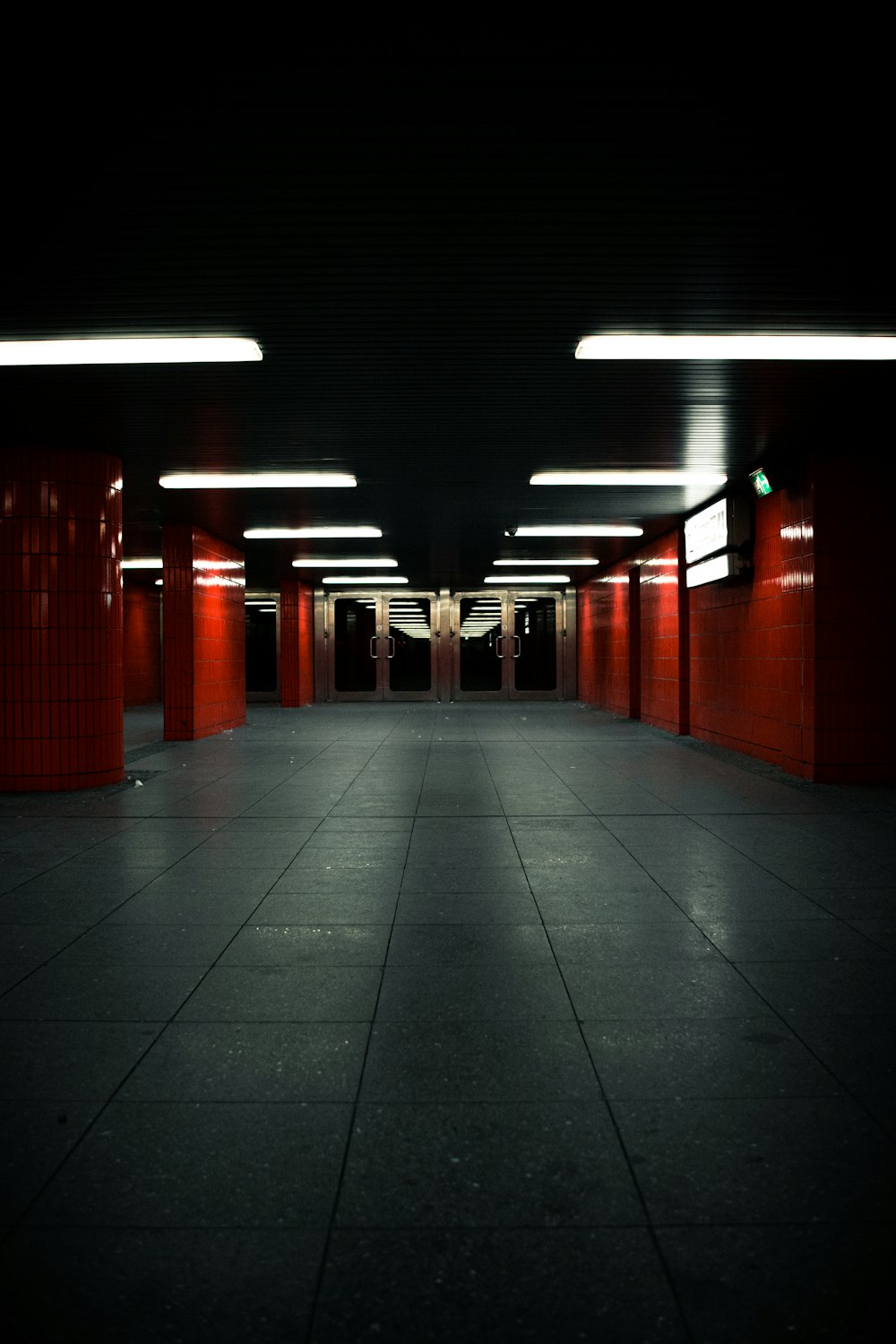 red painted walls and posts hallway with gray tiled floor