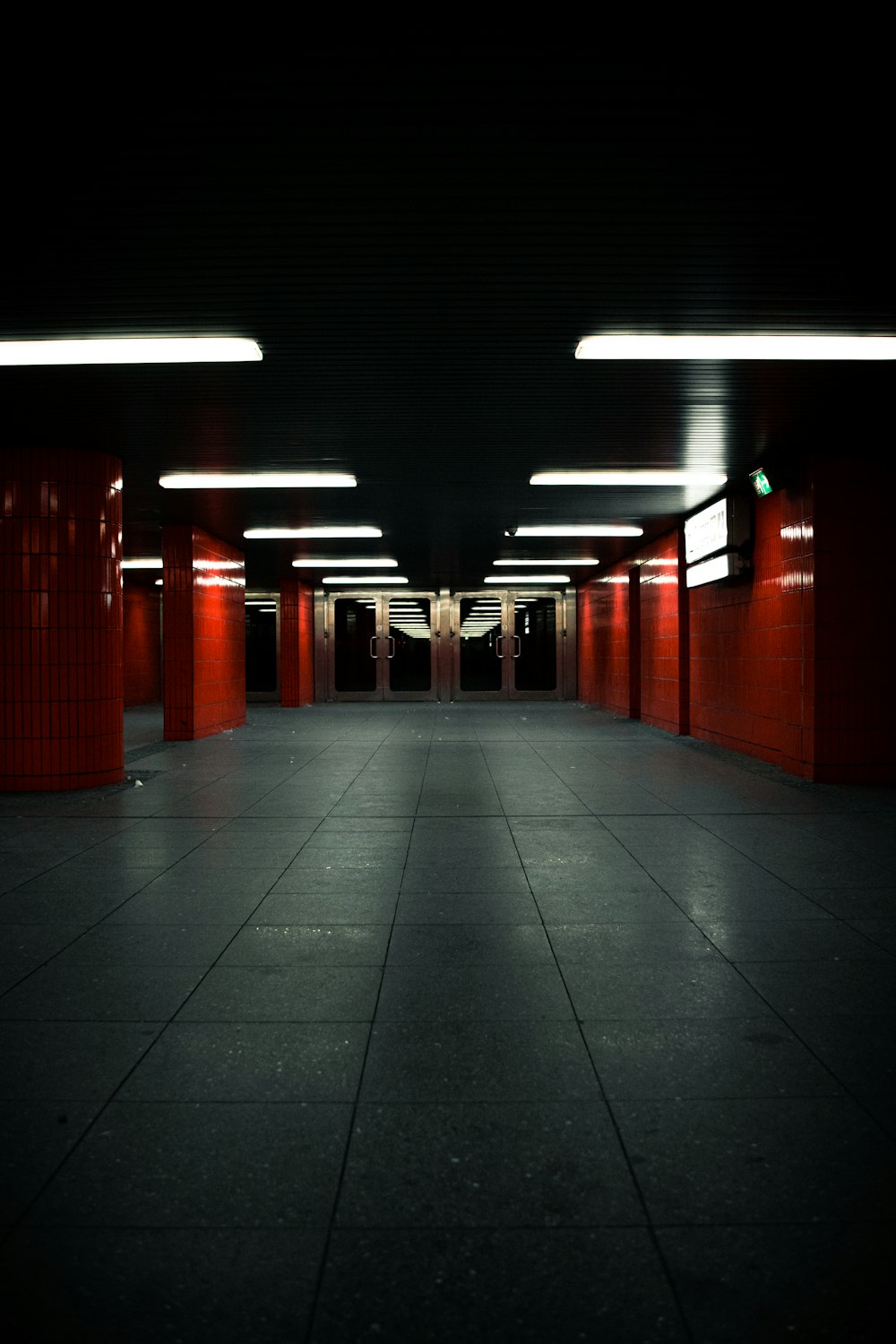Pareti dipinte di rosso e pali corridoio con pavimento piastrellato grigio
