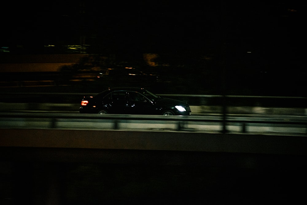 black vehicle on road at night