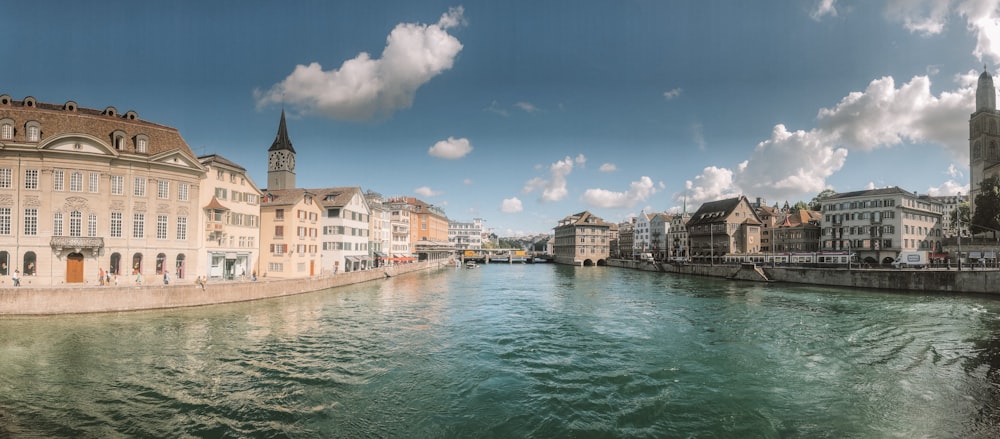 brown buildings near beside calm body of water