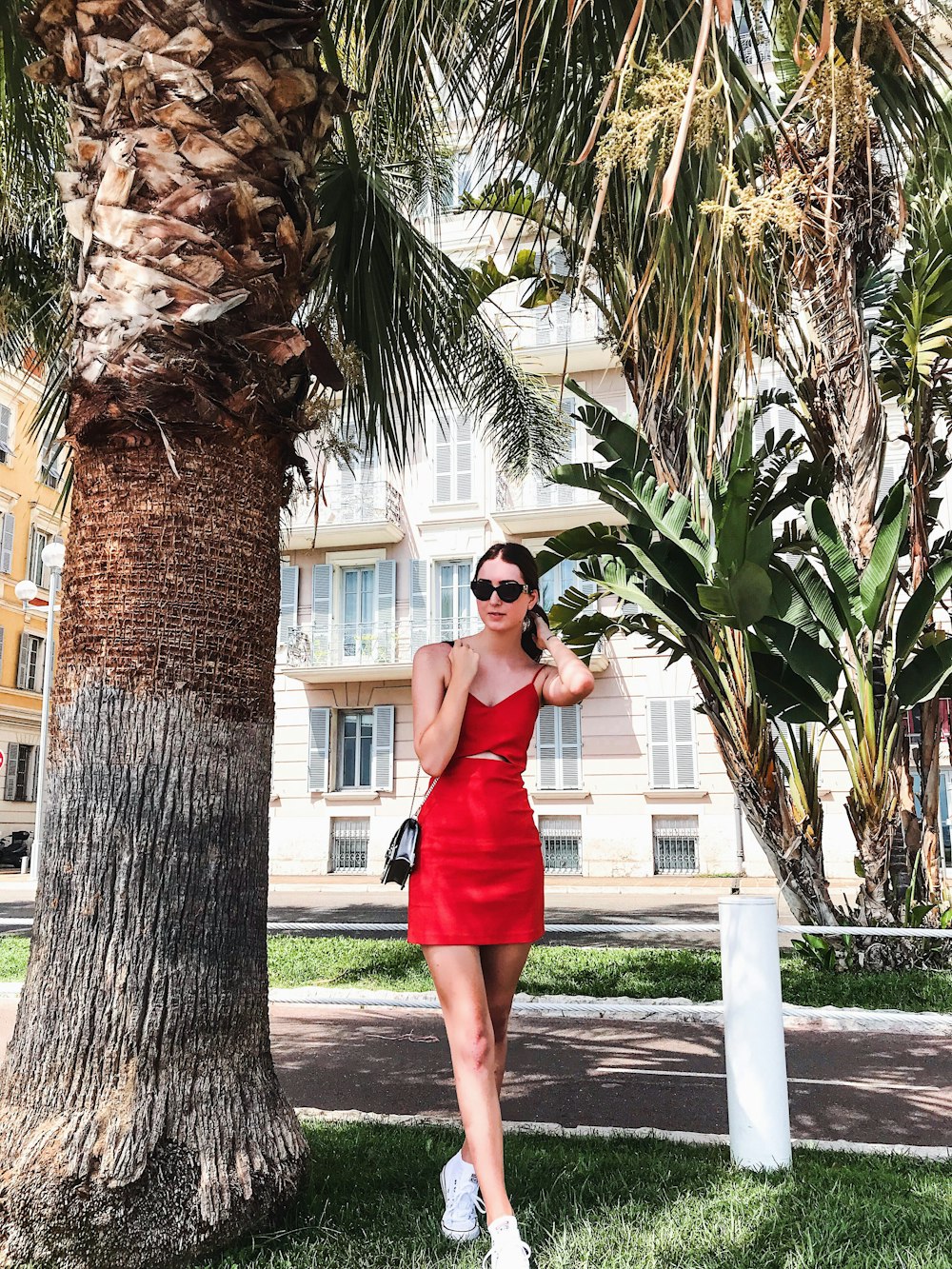 Woman wearing red cami minidress standing outdoor during daytime