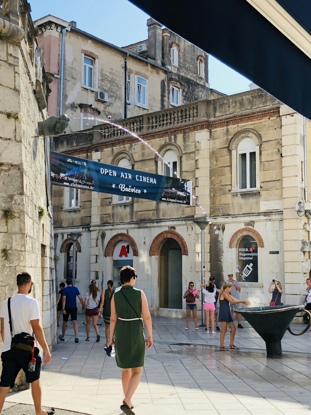 groupe de personnes debout près de bâtiments bruns