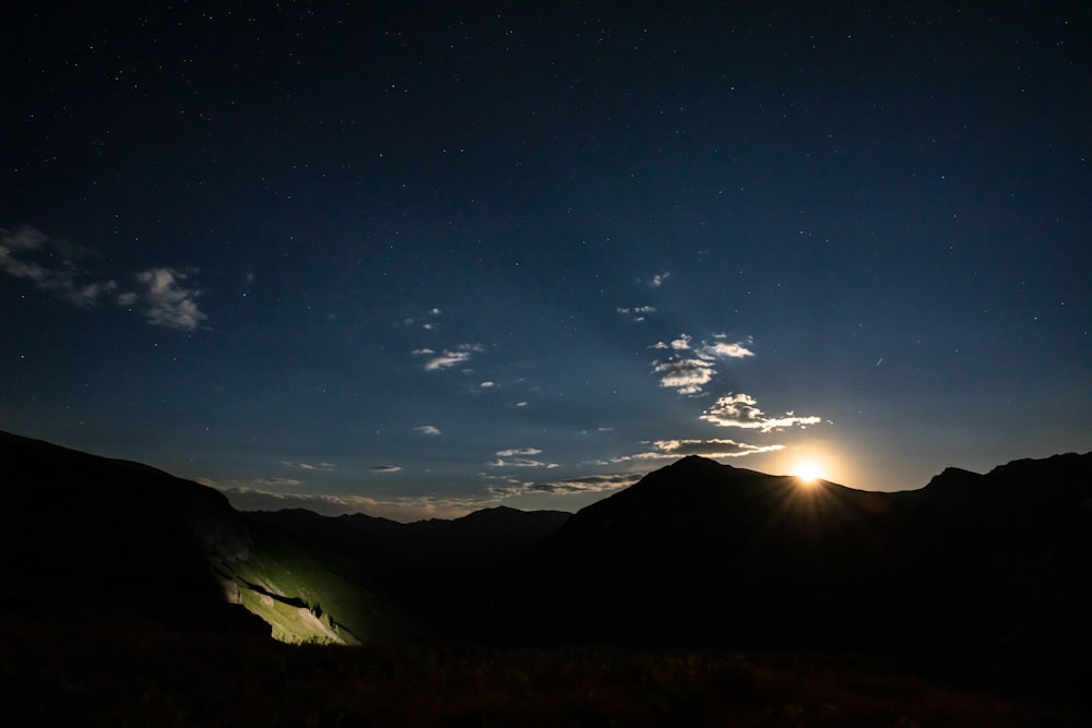 the sun is setting over a mountain range