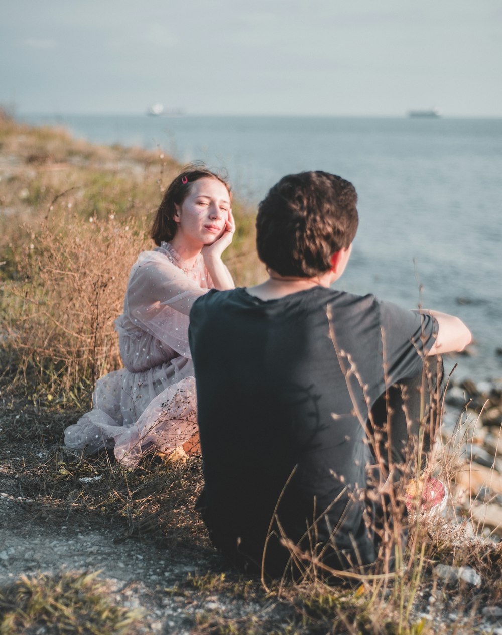 man and woman sitting on ground during daytime